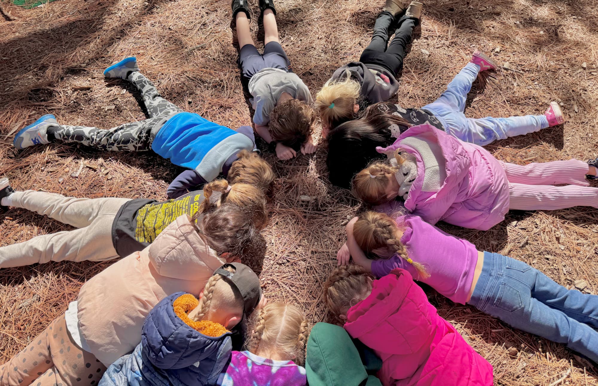Kids lying in a circle outdoors