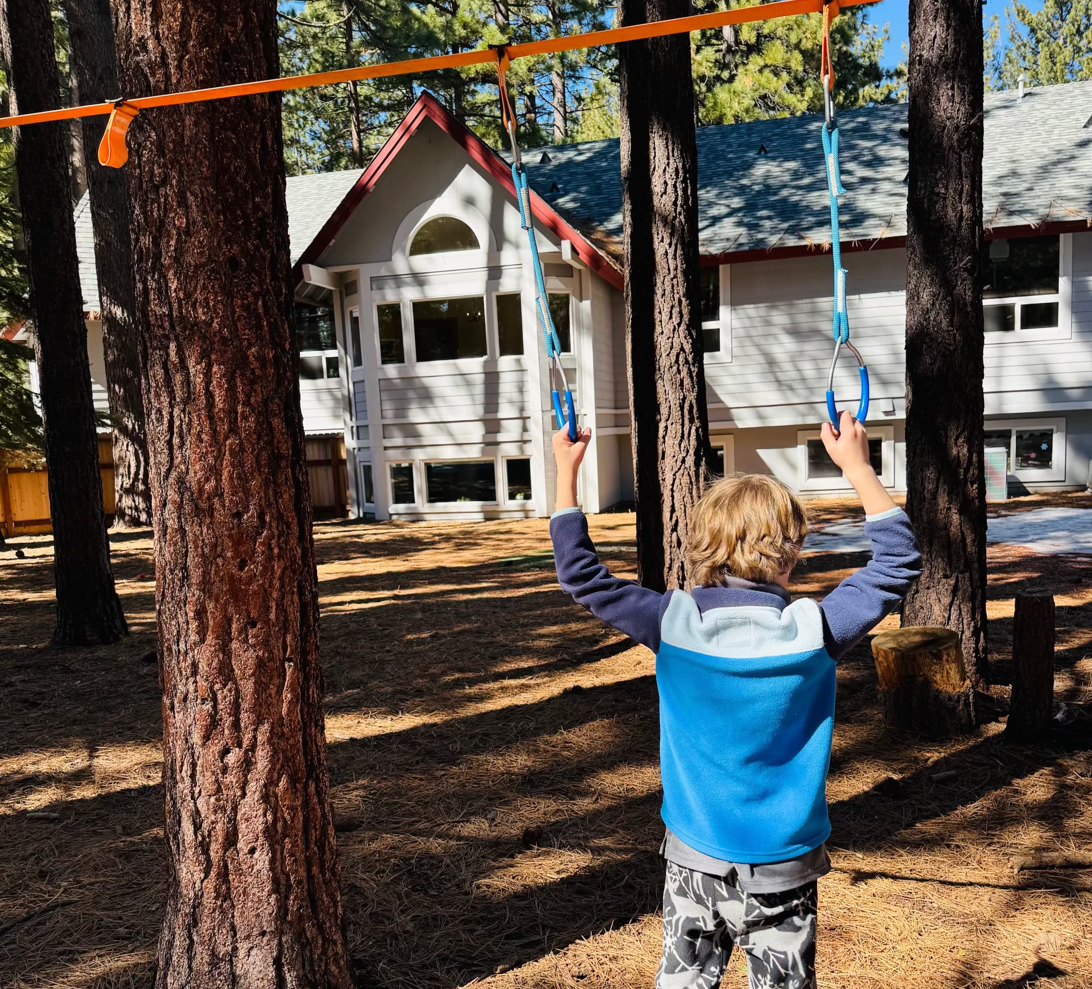 Kid hanging on rings outdoors